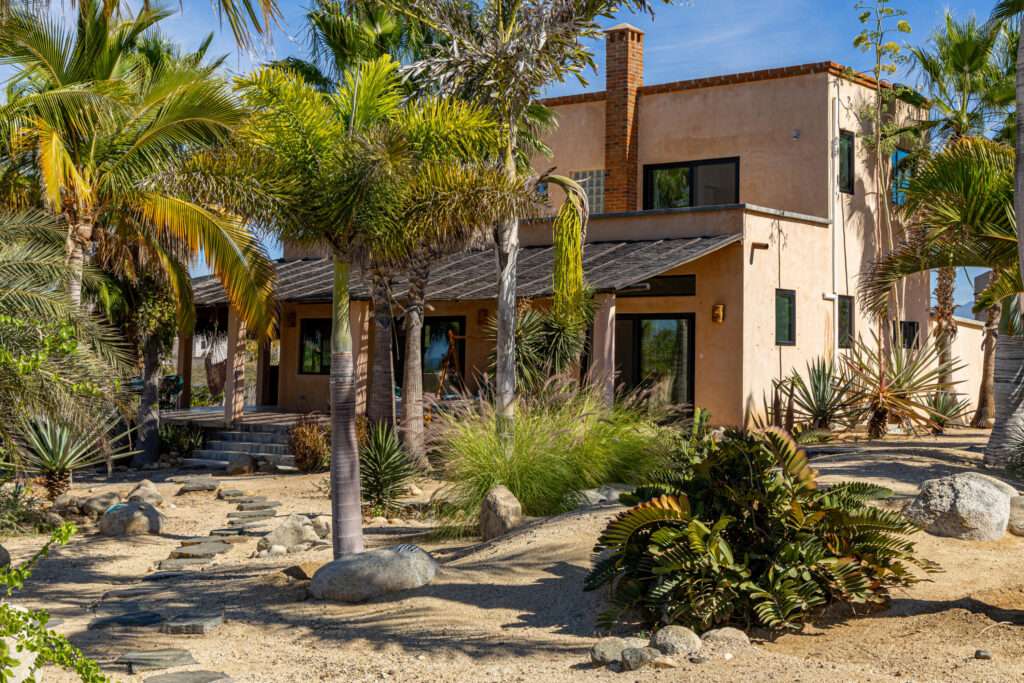 Pedregal Las Tunas Beautifully built and well maintained 3 bedroom, 3.5 bath home steps to the beach in Las Tunas, Todos Santos! Walled, fenced and gated with a big heated swimming pool and pool house with 3 pce bath. Sprawling lot with mature palm trees, native plants and gardens. Ocean – CAMINO INTERNATIONAL, Pacific, BS